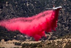 FILE - An air tanker drops fire retardant at the Apple Fire in Cherry Valley, California, August 1, 2020.