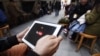 FILE - A man tries to get connected to the YouTube web site with his tablet at a cafe in Istanbul, Turkey, March 27, 2014. Turkey's media regulator wants journalists who operate their own YouTube channels to have broadcast licenses.