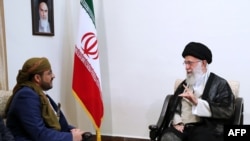 A handout picture provided by the office of Iran's Supreme Leader Ayatollah Ali Khamenei shows him meeting with Mohammed Abdul-Salam, left, spokesman for Yemen's Huthi rebels, during their meeting at Khamenei's residence in Tehran, Aug. 13, 2019.