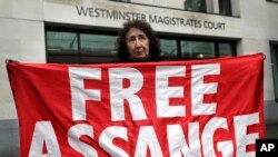 A demonstrator holds a banner outside Westminster Magistrates Court in London, Feb. 19, 2020. 