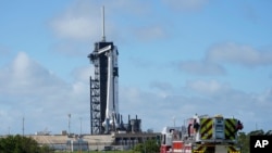 NASA firefighters drive on the road outside the fence near a SpaceX Falcon 9 rocket, with the company's Crew Dragon capsule attached, sits on the launch pad at Launch Complex 39A Nov. 13, 2020, at the Kennedy Space Center in Cape Canaveral, Fla.