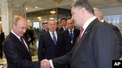 Presiden Ukraina Petro Poroshenko (kanan) berjabat tangan dengan Presiden Rusia Vladimir Putin di Minsk, Belarus (26/8).