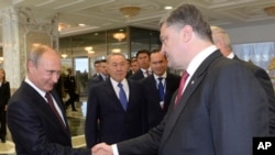 À esquerda Vladimir Putin, aperta a mão de Petro Poroshenko. Ago. 26, 2014. 