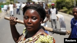 A female protester holds an ax during a protest against Burundian President Pierre Nkurunziza's decision to run for a third term in Bujumbura, Burundi, May 13, 2015.