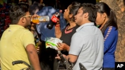 Indian teenagers eat and drink outside a street food stall, in New Delhi, March 9, 2016. India's health minister says the number of obese teenagers in the country has nearly doubled over the last five years, with economic growth fueling lifestyle changes including a fondness for fast food. 