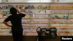 Seorang pelanggan menatap rak-rak yang hampir kosong di sebuah supermarket ketika orang-orang bergegas untuk bersiap-siap menghadapi Topan Hagibis di Tokyo, Jepang, 11 Oktober 2019. (Foto: Reuters)