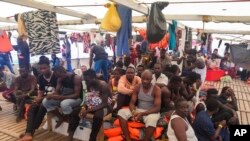 Migrants are seen aboard the Open Arms Spanish humanitarian boat as it cruises in the Mediterranean Sea, Aug. 9, 2019. 