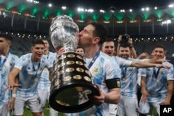 Lionel Messi mencium trofi usai mengalahkan Brazil 1-0 dalam pertandingan sepak bola final Copa America di stadion Maracana di Rio de Janeiro, Brazil, Sabtu, 10 Juli 2021. (Foto: AP)