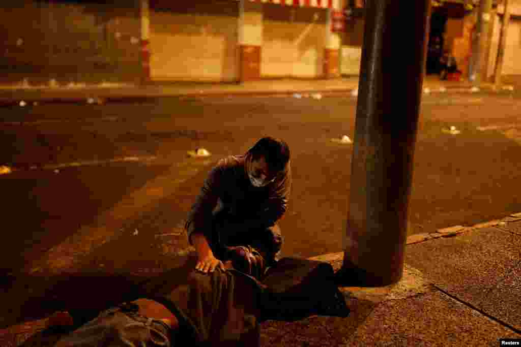 A man helps a patient who was beaten by unknown assailants after leaving the San Juan de Dios hospital, as the coronavirus disease (COVID-19) outbreak continues, in Guatemala City, Guatemala, July 15, 2020.