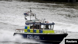 FILE - A police launch travels along the Thames near London Bridge.