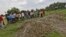Villagers stand next to mass graves of the school children who died after consuming contaminated meals given to them at a school of the Chapra district, in the eastern Indian state of Bihar, July 18, 2013. 