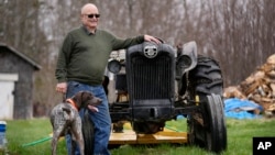 Čarli Robins, protivnik projekta, pored svog traktora i psa.