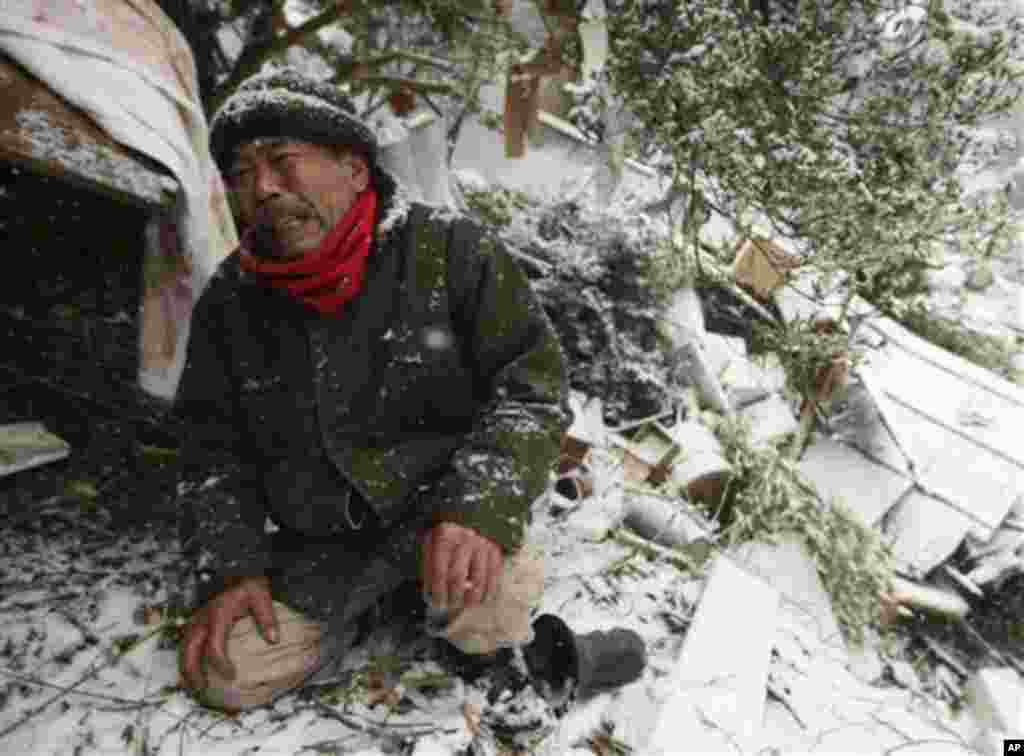 Yoshikatsu Hiratsuka grieves in front of wreckage where the body of his mother is buried in Onagawa. Hiratsuka kept crying out, saying "Sorry, Sorry" that he couldn't have helped her from tsunami. (AP Image)