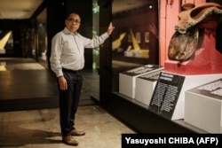 I Gusti Agung Wesaka Puja, Ketua Tim Repatriasi Koleksi Indonesia di Belanda, berpose di depan koleksi artefak yang direpatriasi di Museum Nasional Indonesia di Jakarta. (Foto: Yasuyoshi CHIBA/AFP)