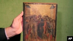 Art expert Stephane Pinta points to a 13th century painting by Italian master Cimabue in Paris, Sept. 24, 2019. 