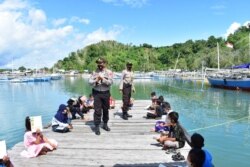 Kegiatan belajar bersama anak-anak pulau Lutungan bersama anggota Polsek Baolan yang di gelar di dermaga tepi pantai pulau Lutungan, Kelurahan Nalu, Kecamatan Baolan, Kabupaten Tolitoli. Kamis, 6 Agustus 2020. Foto : Humas Polres Tolitoli