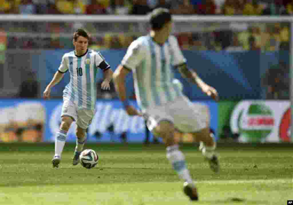 Argentina's Lionel Messi, left, runzs with the ball during the World Cup quarterfinal soccer match between Argentina and Belgium at the Estadio Nacional in Brasilia, Brazil, Saturday, July 5, 2014. (AP Photo/Martin Meissner)