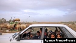 FILE - Palestinian children look on as they are driven home from school in Gaza City on December 9, 2021. 