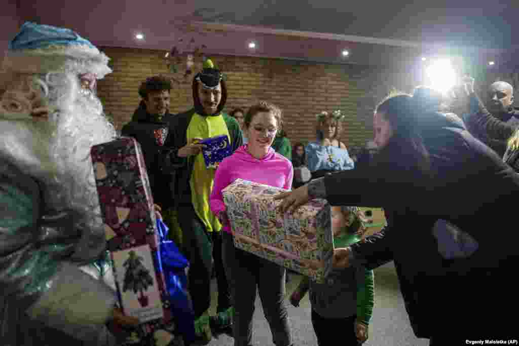 Niños ucranianos reciben regalos de voluntarios de la ONG Ukrainian Frontiers durante las celebraciones del Día de San Nicolás en Izium, Ucrania, el 6 de diciembre de 2024.