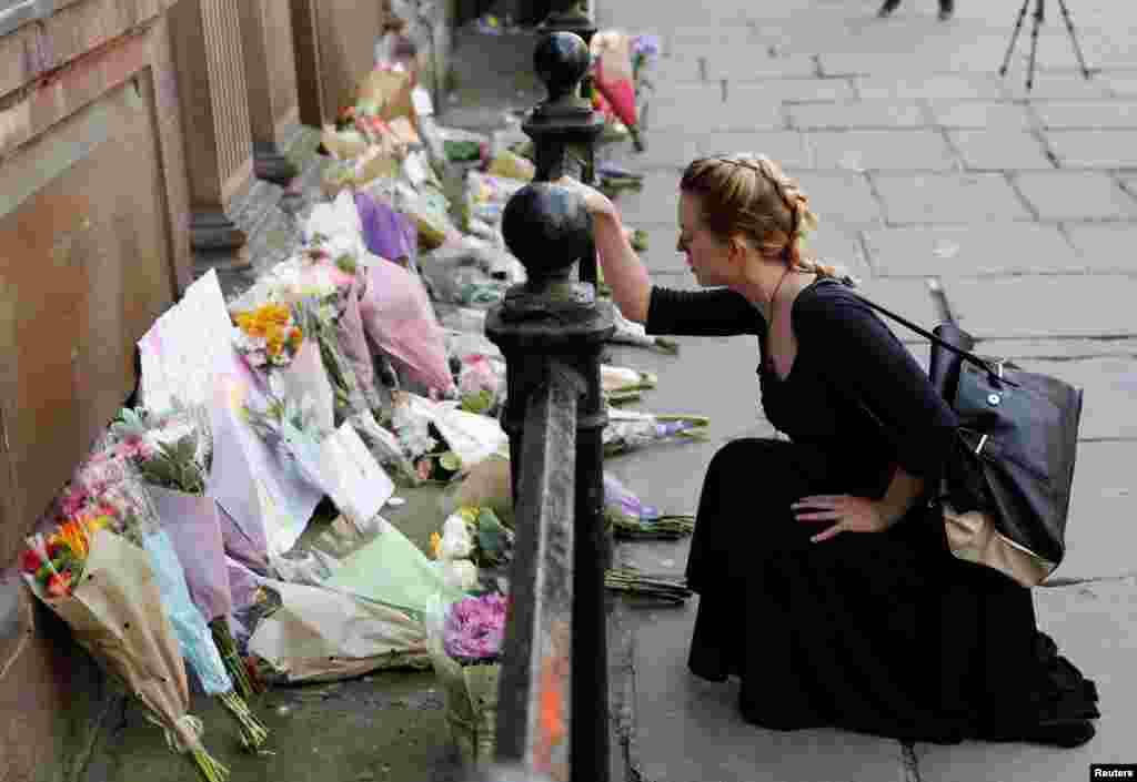 A woman lays flowers for the victims of the Manchester Arena attack, in central Manchester, Britain, May 23, 2017. 