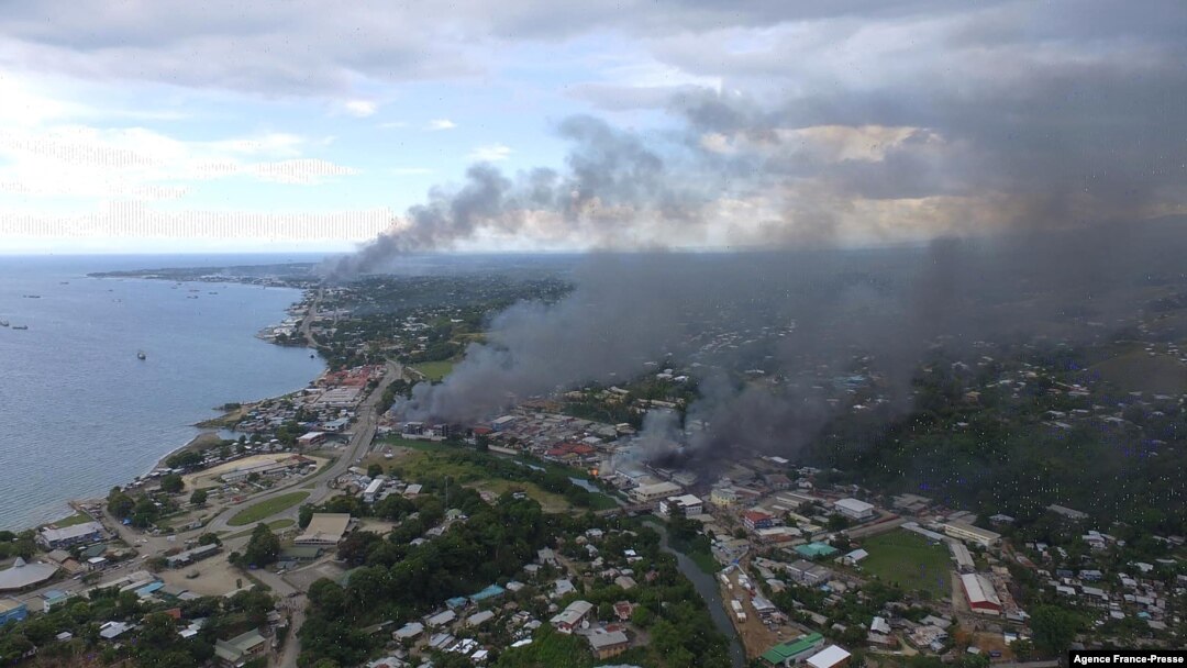 Smoke from burning buildings rise from Honiara on the Solomon Islands on Nov. 25, 2021, on the second day of rioting that left the capital ablaze and threatened to topple the Pacific nation's government. 