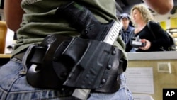 Kayla Brown wears her gun on her hip while working at the Spring Guns and Ammo store in Spring, Texas, January. 4, 2016.