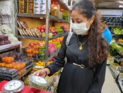 A customer looks at a box of microgreens. (Anjana Pasricha/VOA)