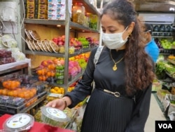 A customer looks at a box of microgreens. (Anjana Pasricha/VOA)