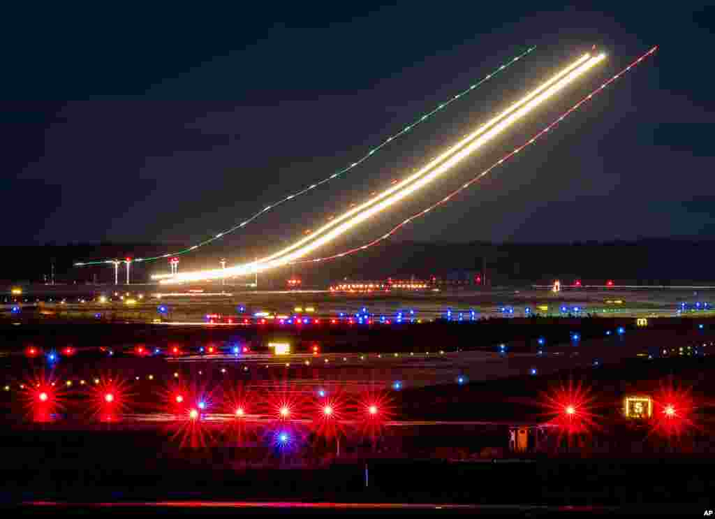 This long time exposure photo shows the lights of an aircraft while landing at the airport in Frankfurt, Germany.