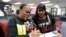 FILE - Former felon Yolanda Wilcox, left, fills out a voter registration form as her friend Gale Buswell looks on at the Supervisor of Elections office in Orlando, Fla., Jan. 8, 2019. 