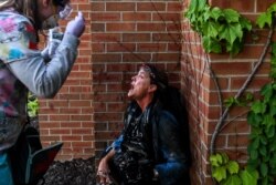 FILE - A medic protester assists a member of the media after police fired tear gas and rubber bullets during a demonstration for George Floyd, a Black man who died while in custody of the Minneapolis police, in Minneapolis, Minnesota, May 30, 2020.