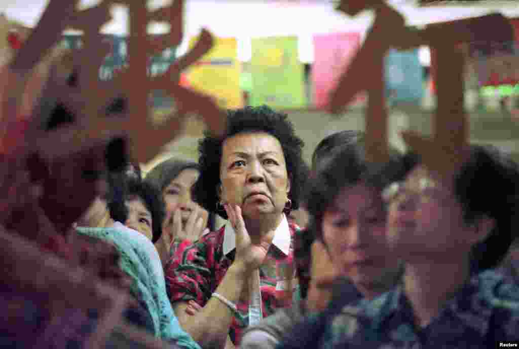 A small investor watches share prices inside a bank in Hong Kong, Dec. 1, 1998. Hong Kong surprised markets with a $15 billion intervention in August 2008, saving the city in the crisis.