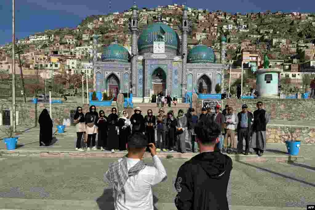 گروهی از سیاحین از تایلند در حال گرفتن عکس در مقابل زیارت سخی در شهر کابل