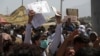 FILE — Hundreds gather, some holding documents, near an evacuation control checkpoint on the perimeter of the Hamid Karzai International Airport, in Kabul, Afghanistan, Aug. 26, 2021.