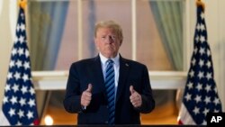 Presiden Donald Trump mengacungkan dua jempol dari Blue Room Balcony setibanya di Gedung Putih setelah dirawat di RS Militer Nasional Walter Reed, di Bethesda, Maryland, 2 Oktober 2020. (Foto: AP)