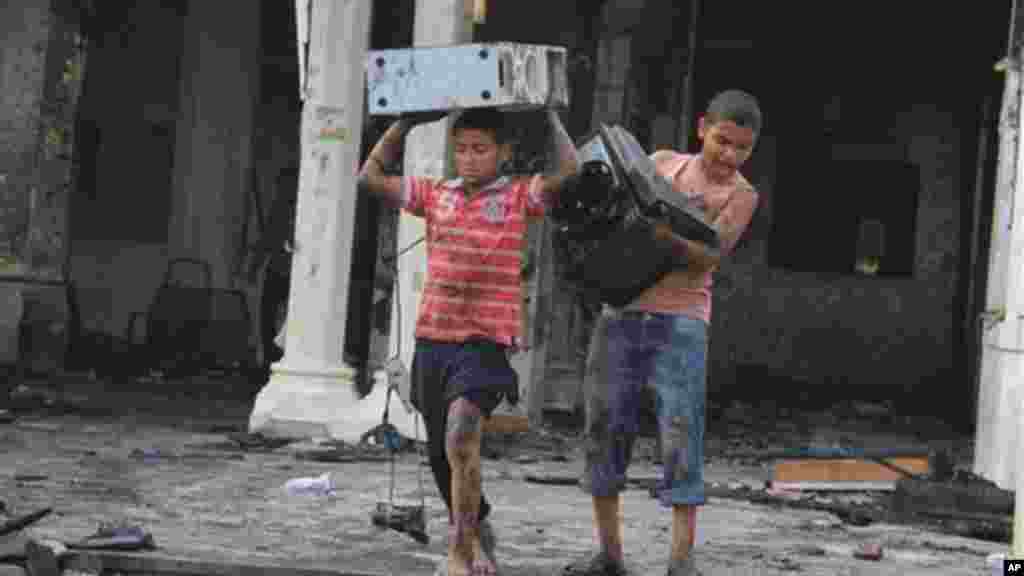 Egyptian children carry computer equipment in the burned remains of the Rabaah al-Adawiya mosque, in the center of the largest protest camp of supporters of ousted President Morsi,