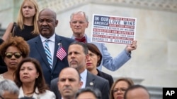 ARCHIVO - El representante Earl Blumenauer, D-Ore., sostiene un letrero mientras los demócratas de la Cámara se reúnen en los escalones del Capitolio para pedir la aprobación de la Ley Keep Families Together, para terminar con la política de la administración Trump de separar familias en la frontera de EE.UU. con México. Washington, 20 de junio de 2018.