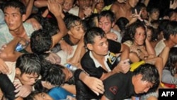 Những đám đông xô nhau băng qua cầu, khiến cho nhiều người bị rơi xuống sông ở Phnom Penh, Campuchia, Thứ Hai 22/11/2010