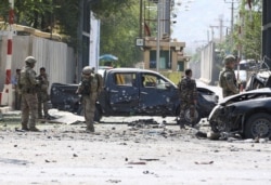 FILE - Foreign troops with NATO-led Resolute Support Mission investigate at the site of a suicide attack in Kabul, Afghanistan, Sept. 5, 2019.