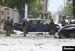 FILE - Foreign troops with the NATO-led Resolute Support Mission investigate at the site of a suicide attack in Kabul, Afghanistan, Sept. 5, 2019.