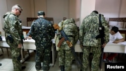 Dân quân vũ trang tân Nga đăng ký trước khi bỏ phiếu tại một địa điểm bầu cử ở Slaviansk, miền đông Ukraine, ngày 11/5/2014.