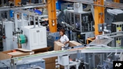 FILE - An employee works on a factory floor at a Stihl Inc. production plant in Virginia Beach, Va, May 25, 2017. 