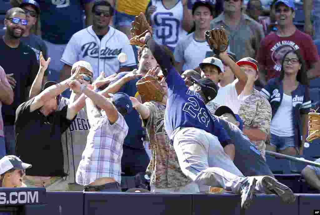 Colorado Rockies third baseman Nolan Arenado (28) leaps into the stands but cannot reach a foul ball hit by San Diego Padres&rsquo; Wil Myers during the sixth inning of a baseball game in San Diego, California, Sept. 7, 2015. Myers would later strike out, with the bases loaded, in the at-bat.
