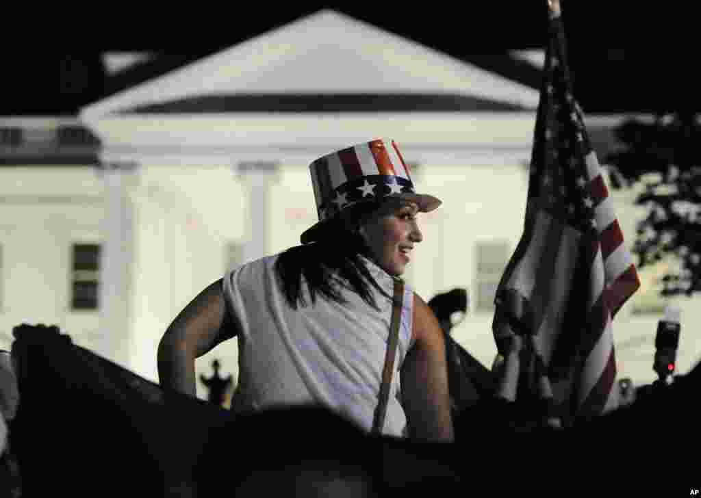 A woman sits on a reveler's shoulders outside the gates of the White House after U.S. President Barack Obama announced that U.S. authorities have recovered the dead body of al-Qaida leader Osama bin Laden, May 1, 2011 (Reuters)