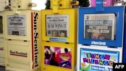 FILE - The Fort Lauderdale Sun-Sentinel, The Miami Herald and El Nuevo Herald sit in newsstands in North Miami-Dade Florida, Nov. 8, 2000. The Miami Herald is among the organizations participating in a Report for America program to hire local journalists.