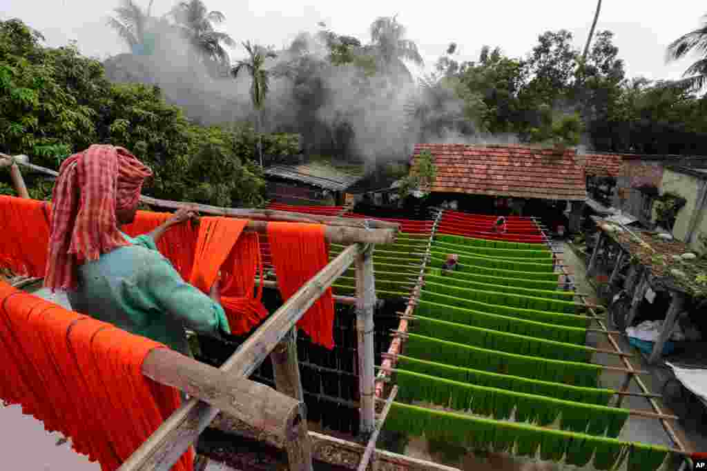 Laborers hang colored yarn to dry in Santipur, about 120 kilometers north of Kolkata, India.&#160;