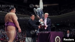 U.S. President Donald Trump prepares to present the President’s Cup to wrestler Asanoyama, the winner of the Summer Grand Sumo Tournament at Ryogoku Kokigikan Sumo Hall in Tokyo, May 26, 2019.