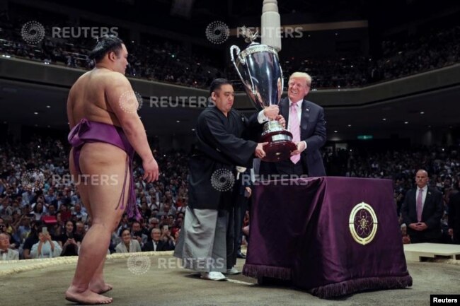El presidente de EE.UU., Donald Trump, se prepara para entregar la Copa del Presidente al luchador de sumo Asanoyama, ganador del Gran Torneo de Sumo de Verano en el Ryogoku Kokigikan Sumo Hall, en Tokio. Mayo 26, de 2019.