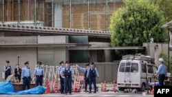 Police investigate a vehicle that crashed into a barricade outside the prime minister's Tokyo residence on Oct. 19, 2024, after a man threw Molotov cocktail-like objects outside the ruling party's headquarters building, hit a riot police vehicle and drove into the barricade.