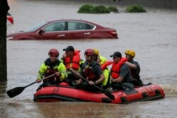 FILE - Residents of the Crescent at Lakeshore apartment complex are rescued by Homewood Fire and Rescue as severe weather produced torrential rainfall flooding several apartment buildings, May 4, 2021 in Homewood, Ala. (AP Photo/Butch Dill)